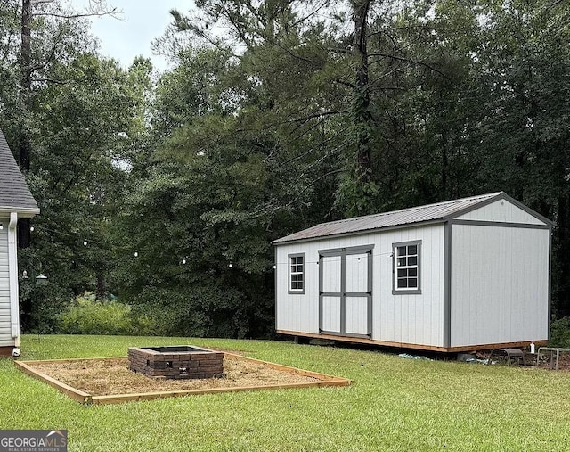 view of outbuilding featuring a yard and an outdoor fire pit