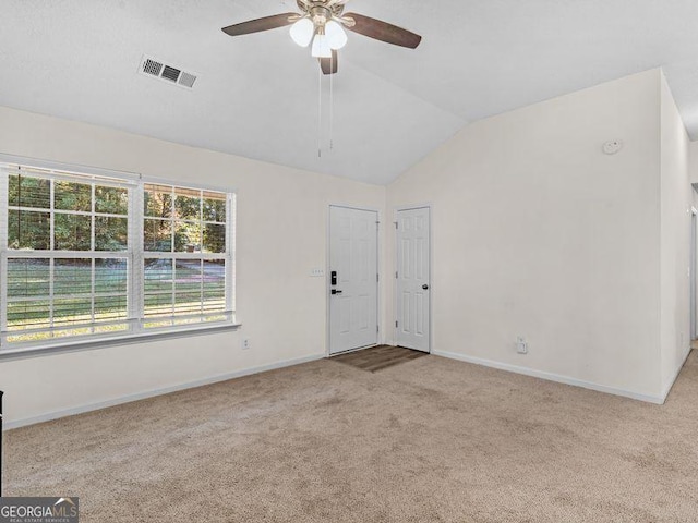 carpeted spare room featuring ceiling fan and vaulted ceiling