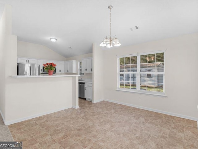 kitchen with white cabinetry, hanging light fixtures, stainless steel appliances, a notable chandelier, and vaulted ceiling