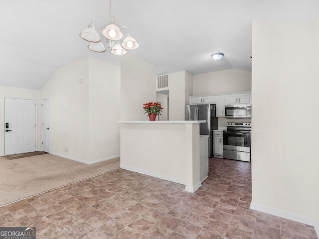 kitchen with white cabinetry, hanging light fixtures, stainless steel appliances, a chandelier, and vaulted ceiling