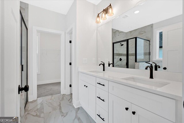 bathroom featuring a shower with door and vanity