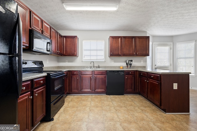 kitchen featuring light stone countertops, sink, kitchen peninsula, a textured ceiling, and black appliances