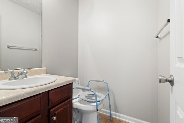 bathroom featuring vanity, toilet, and a textured ceiling