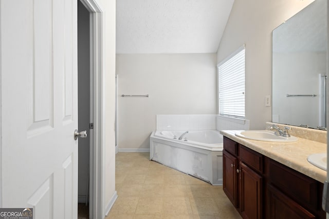 bathroom with a washtub, a textured ceiling, vanity, vaulted ceiling, and tile patterned flooring