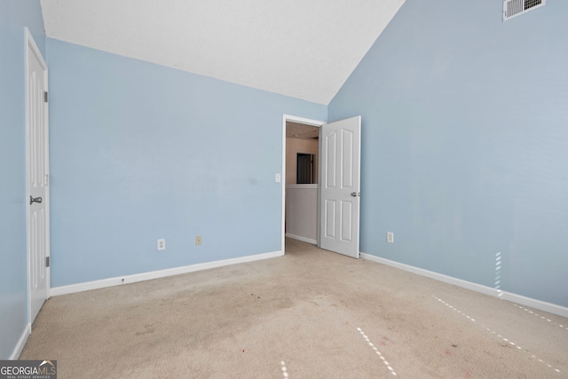 unfurnished room featuring light carpet and high vaulted ceiling