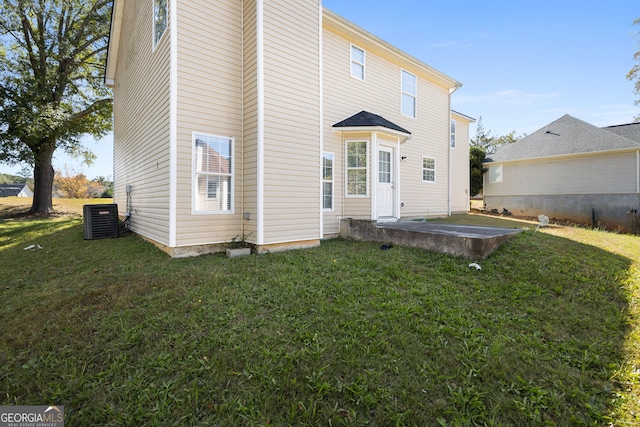 back of house with central air condition unit, a patio area, and a yard