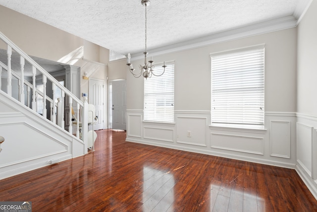 unfurnished dining area featuring a healthy amount of sunlight, a textured ceiling, and a chandelier