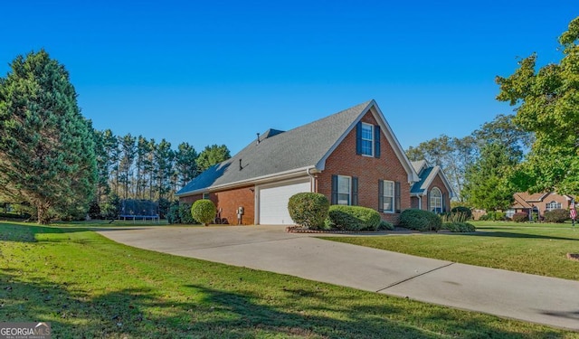 view of side of home featuring a lawn, a garage, and a trampoline