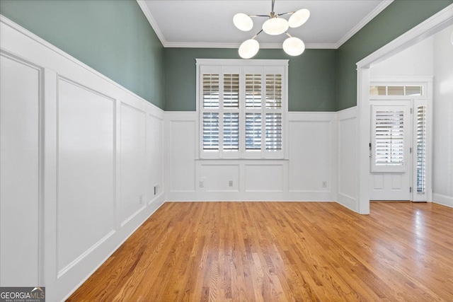 unfurnished dining area with a notable chandelier, plenty of natural light, and ornamental molding