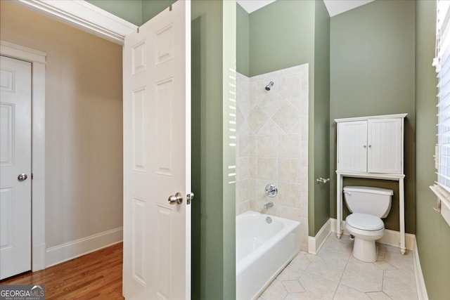 bathroom with tile patterned floors, plenty of natural light, toilet, and a tub