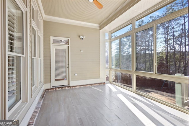 unfurnished sunroom with ceiling fan