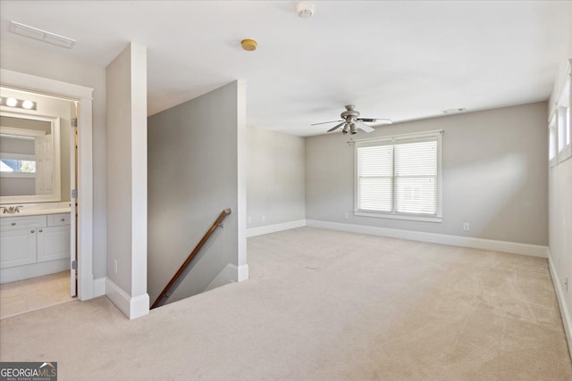 carpeted spare room featuring ceiling fan