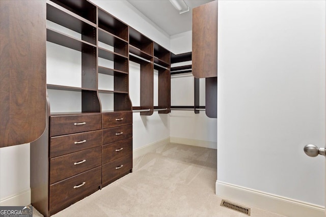 walk in closet featuring light colored carpet