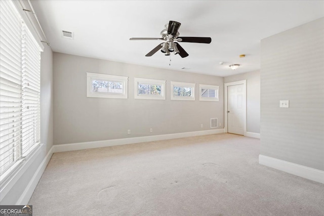 carpeted empty room featuring plenty of natural light and ceiling fan