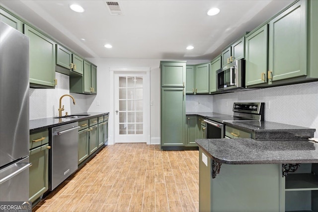 kitchen featuring sink, stainless steel appliances, and green cabinetry