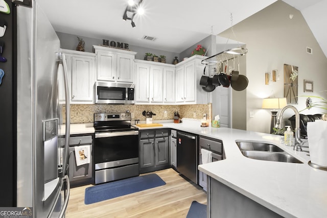 kitchen featuring gray cabinetry, sink, decorative backsplash, white cabinets, and appliances with stainless steel finishes