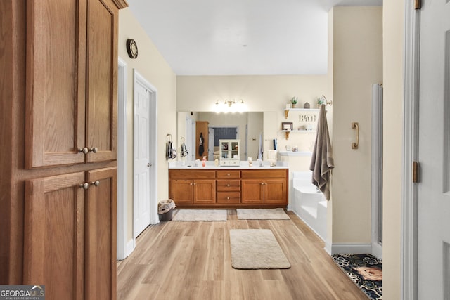 bathroom featuring vanity, wood-type flooring, and a tub