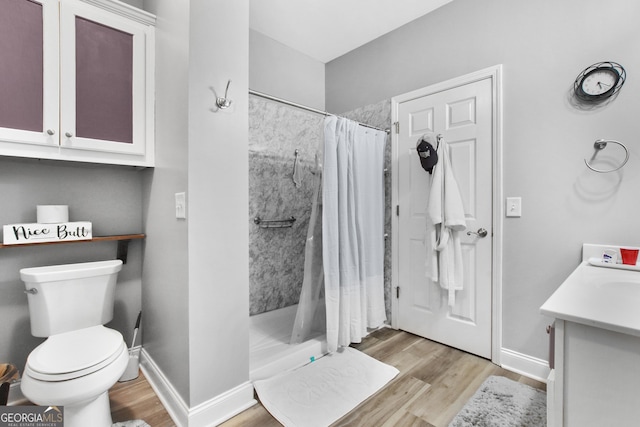 bathroom with a shower with curtain, vanity, hardwood / wood-style flooring, and toilet