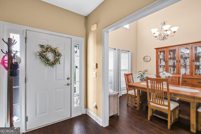 foyer with dark hardwood / wood-style flooring and a notable chandelier