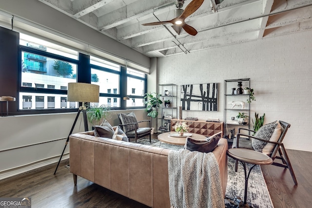 living room with ceiling fan, brick wall, dark wood finished floors, and baseboards