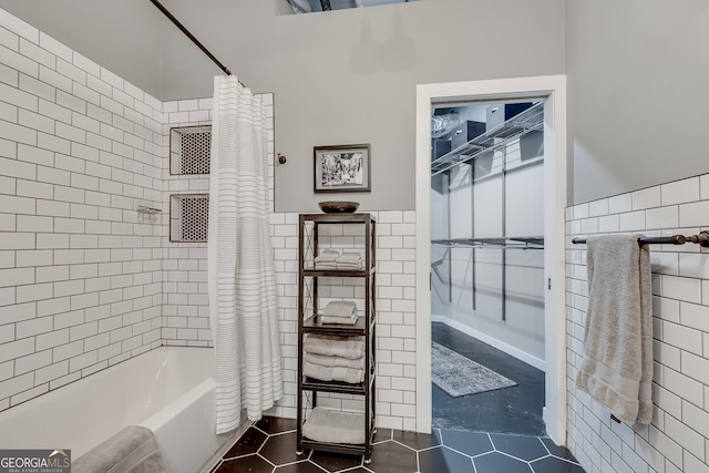 bathroom featuring shower / tub combo with curtain and tile walls