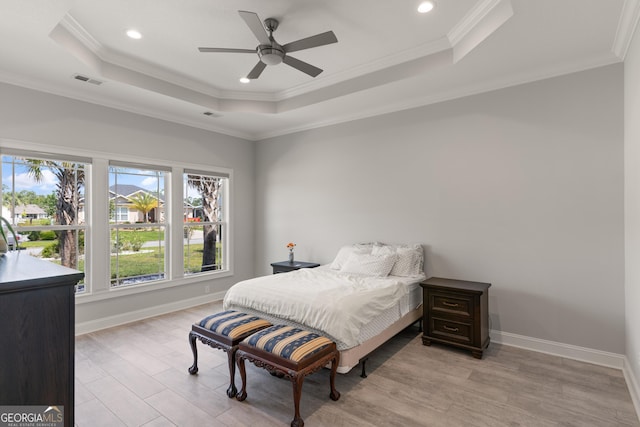 bedroom featuring a tray ceiling, ceiling fan, light hardwood / wood-style flooring, and ornamental molding