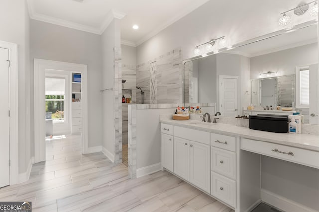 bathroom featuring a tile shower, vanity, and ornamental molding