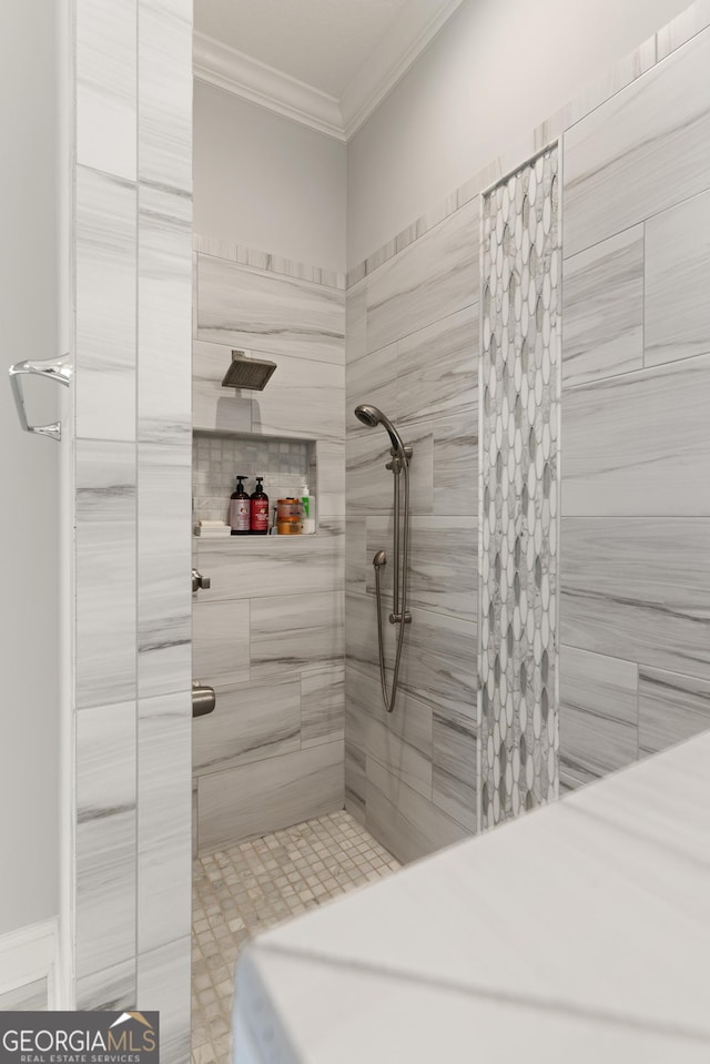 bathroom featuring ornamental molding and tiled shower