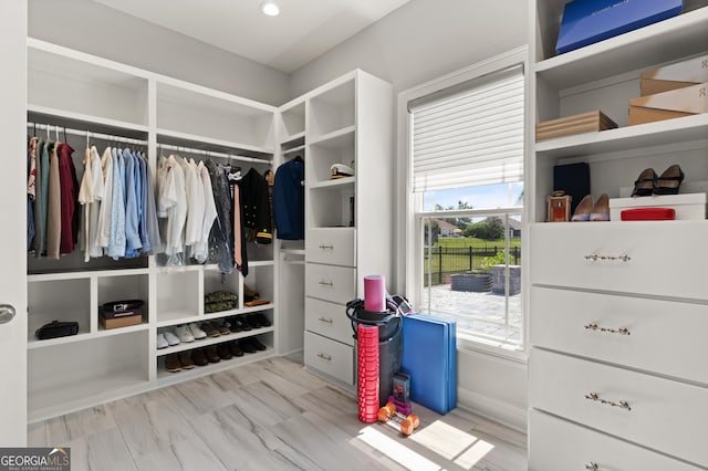 walk in closet with light hardwood / wood-style floors