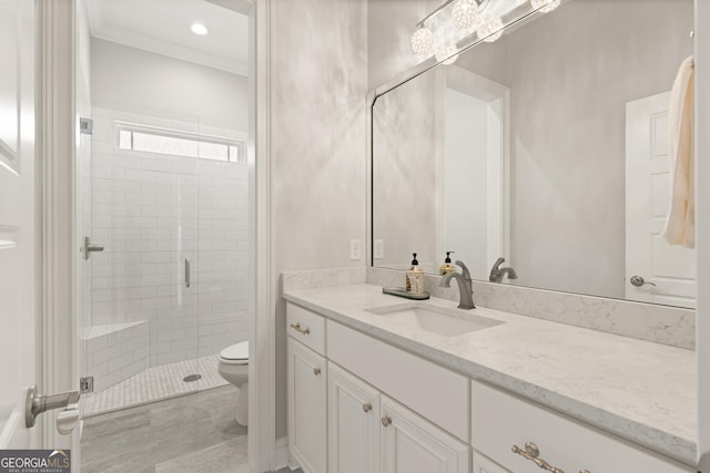 bathroom with an enclosed shower, vanity, toilet, and crown molding