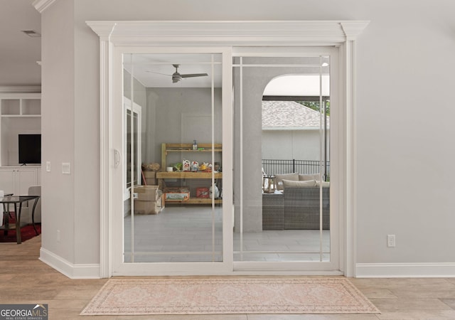 interior space with ceiling fan, light hardwood / wood-style floors, and ornamental molding