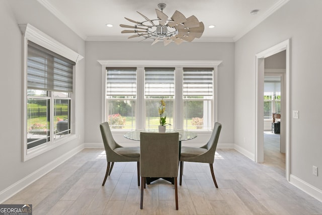 dining space with crown molding and light hardwood / wood-style floors