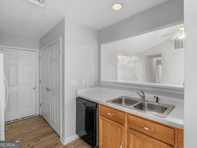 kitchen featuring sink, light hardwood / wood-style flooring, ceiling fan, a textured ceiling, and black dishwasher