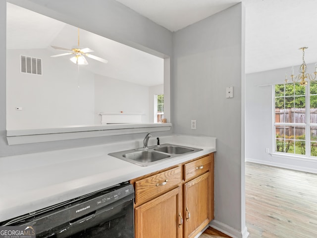 kitchen featuring dishwasher, sink, vaulted ceiling, ceiling fan with notable chandelier, and light wood-type flooring