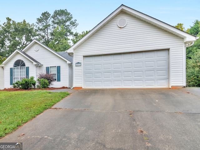 ranch-style home featuring a garage and a front lawn