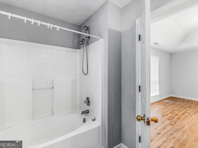 bathroom featuring bathtub / shower combination, a textured ceiling, and hardwood / wood-style flooring