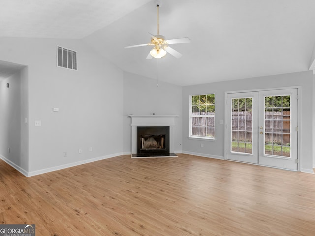 unfurnished living room featuring ceiling fan, vaulted ceiling, light wood-type flooring, and french doors