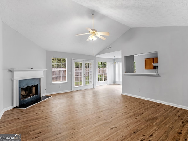 unfurnished living room with a textured ceiling, ceiling fan, light hardwood / wood-style flooring, and lofted ceiling