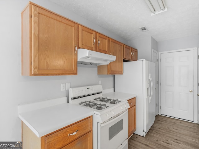 kitchen with a textured ceiling, light hardwood / wood-style floors, and white gas range oven