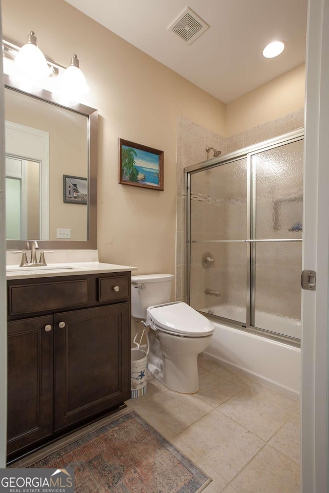 full bathroom featuring tile patterned floors, visible vents, toilet, shower / bath combination with glass door, and vanity