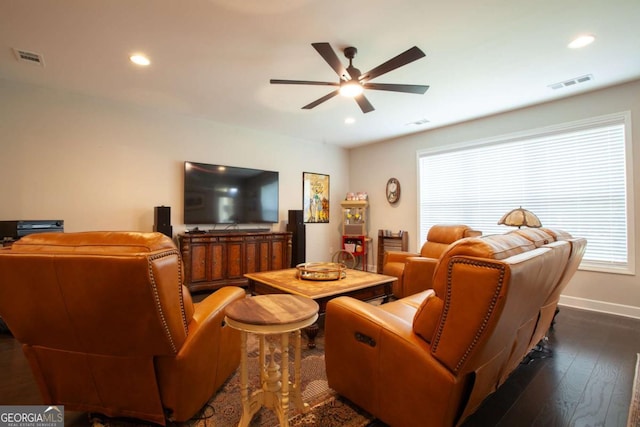 living area with dark wood-style floors, visible vents, and a healthy amount of sunlight