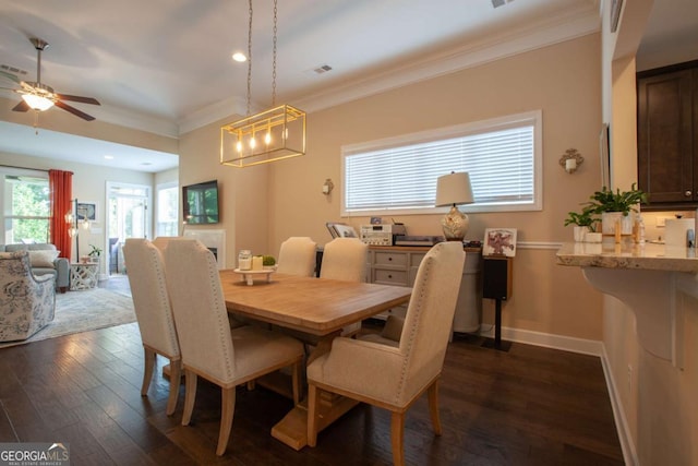 dining area with dark hardwood / wood-style floors, ceiling fan, and ornamental molding