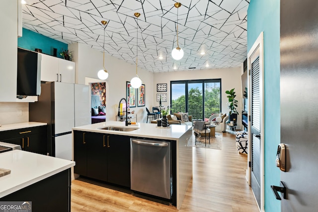 kitchen featuring dishwasher, sink, an island with sink, decorative light fixtures, and white cabinets