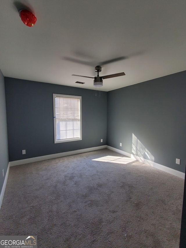 carpeted empty room featuring ceiling fan