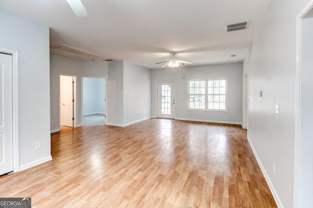 empty room with ceiling fan and light hardwood / wood-style flooring