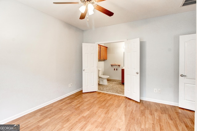 unfurnished bedroom featuring ensuite bath, ceiling fan, and light wood-type flooring