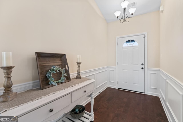 foyer with dark wood-type flooring and a chandelier