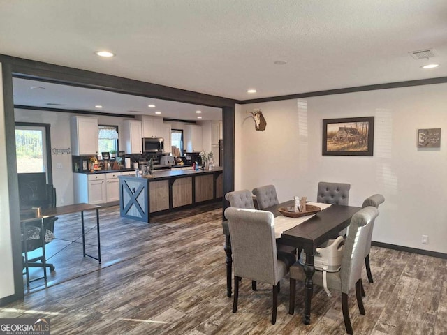 dining space featuring crown molding and dark hardwood / wood-style flooring