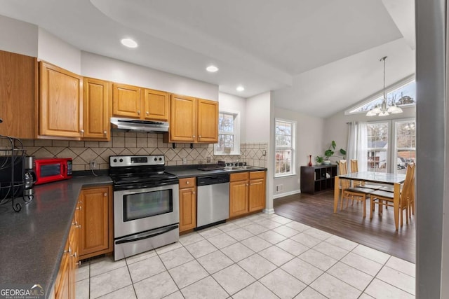 kitchen featuring a chandelier, light tile patterned floors, stainless steel appliances, and lofted ceiling