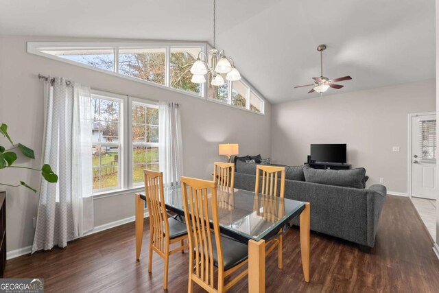 dining area with dark hardwood / wood-style flooring, ceiling fan with notable chandelier, and vaulted ceiling